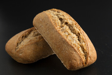 rye bread rolls on black background