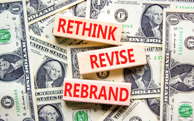 Rethink revise rebrand symbol. Concept word Rethink Revise Rebrand on block. Dollar bills. Beautiful dollar bills background. Business brand motivational rethink revise rebrand concept. Copy space.