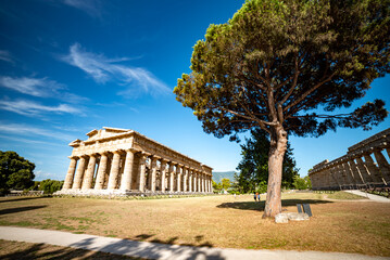 Ancient greek temples located in Italy in Peastum, Salerno with columns and blue sky and sun...