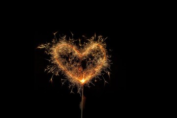 Sparkling bengal fire heart isolated on black background.