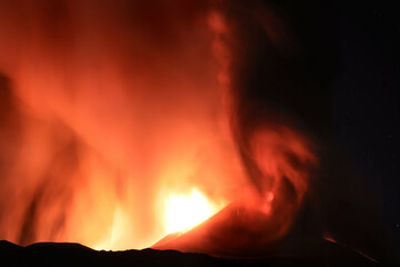 Etna durante suggestiva eruzione di notte con grandi emissioni di vapore nel cielo notturno dal cratere della cima del vulcano del 13 Agosto 2023