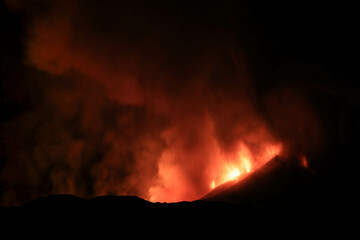 Etna panoramica di notte sul vulcano in eruzione con lava tra cenere gas e vapore nel cielo...