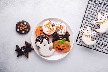 Halloween gingerbread cookies on white plate on stone background. Bright homemade cookies for Halloween party - 649007828