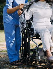 Obraz premium Asian young woman nurse at nursing home take care disabled senior man. Caregiver doctor serve physical therapy for older elderly patient to exercise and practice walking on walker or cane at backyard.