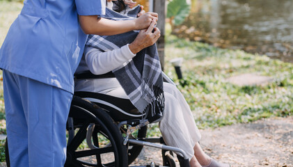 Asian young woman nurse at nursing home take care disabled senior man. Caregiver doctor serve physical therapy for older elderly patient to exercise and practice walking on walker or cane at backyard.