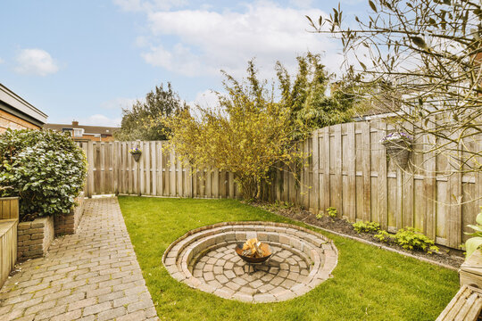 Fire pit and wooden fence in garden at backyard