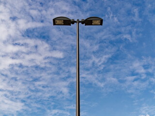 Black metal pole street lamps isolated front of blue sky