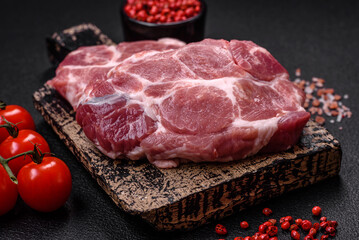 Fresh juicy pork steaks with salt, spices and herbs