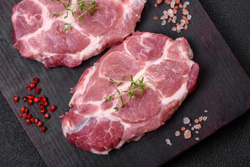 Fresh juicy pork steaks with salt, spices and herbs