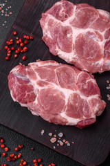 Fresh juicy pork steaks with salt, spices and herbs