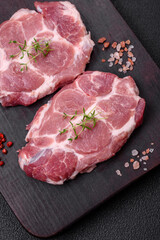 Fresh juicy pork steaks with salt, spices and herbs