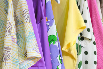 Fashion clothes on clothing rack  Closeup of rainbow color choice female wear on hangers in a clothing store closet  Summer home wardrobe.