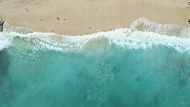 Beach and turquoise ocean with waves in sunny day. Aerial view. Top view