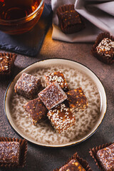 Sugar free candies made from fruit paste, nuts and sesame seeds on a plate vertical view
