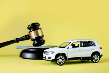 Car auction concept - gavel and car key on yellow background. Accident lawsuit or insurance, court...