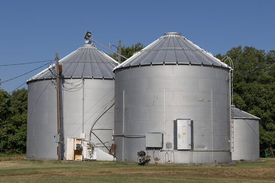 Grain Bins On A Farm In The Midwest US. Grain Bins Can Be Used To Store Wheat, Corn, Oats, Seeds, Soybeans, Sunflower Seeds And Barley.