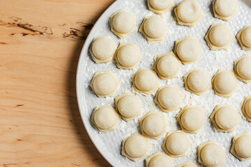 Fototapeta na wymiar Raw homemade dumplings on a wooden table.
