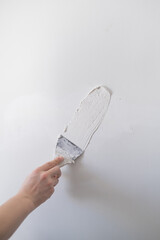 repairing walls with putty and spatula