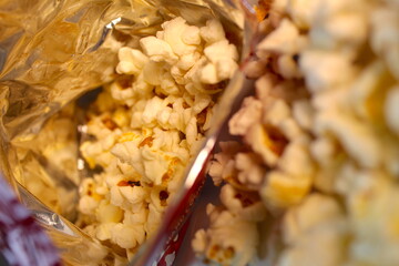 A photo of popcorn snack leaking out of a popcorn packet.