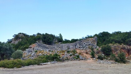 Pinara ruins of an ancient city near Fethiye, Mugla, Türkiye. Lycian tombs, ancient Roman amphitheater and mountains.