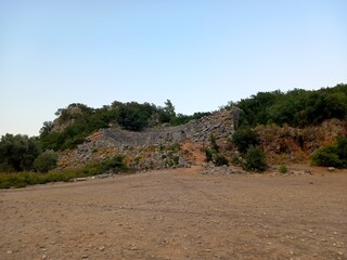 Pinara ruins of an ancient city near Fethiye, Mugla, Türkiye. Lycian tombs, ancient Roman amphitheater and mountains.