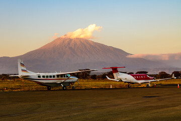 Small propeller airplanes at the airport at sunset, mount Meru at background. Arusha, Tanzania