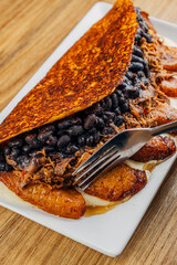 cachapa de pabellon, Venezuelan gastronomy. corn dough stuffed with black beans, fried dishes, meat and cheese