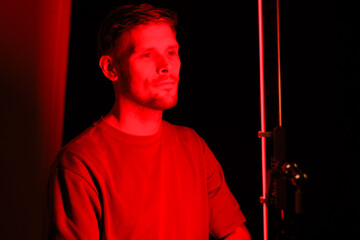 A man undergoing red light therapy, facing the camera in a portrait. He is at a beauty salon using...