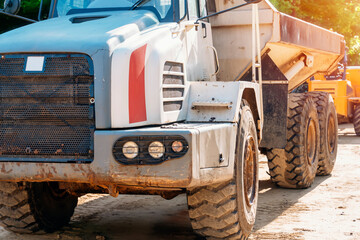 Big articulated dump truck earth mover working on building site
