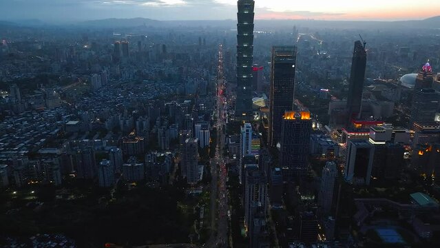 台北の台北101などの高層ビル群と街並みの夜景と夕日　台湾　空撮