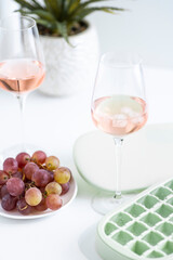 Beautiful background with glasses of wine, ice and grapes
