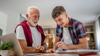 student caucasian male teenager and his grandfather or professor study