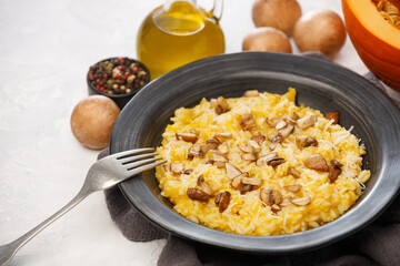 Risotto with pumpkin and mushrooms close-up on a white background, close-up
