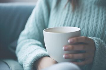 Close-up of a woman enjoying a cup of coffee in her living room. The natural antioxidant and stimulant with the best taste and aroma,A quiet break to reflect and recharge energy - obrazy, fototapety, plakaty