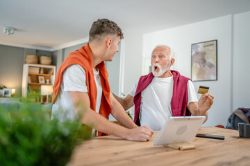 teenager and senior man grandfather use credit card shopping online