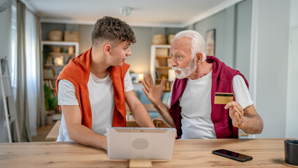 Fototapeta na wymiar teenager and senior man grandfather use credit card shopping online