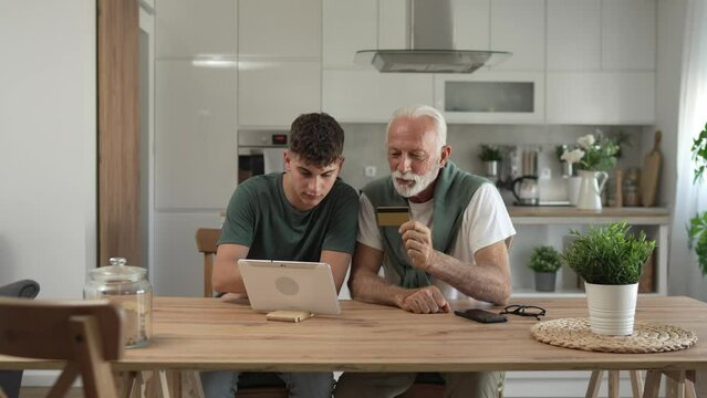 teenager and senior man grandfather use credit card shopping online
