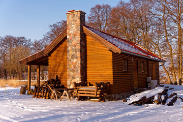 Drewniany dom w lesie zimą.