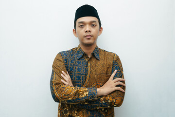 Portrait of Asian Indonesian man wearing batik shirt traditional cloth and black peci or songkok