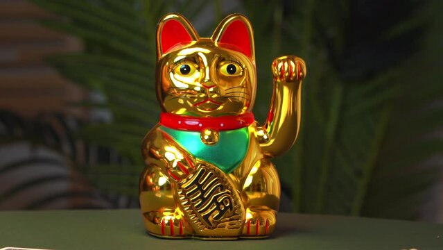 Maneki Neko cat stands on green cloth table with laid out playing cards in casino Decoration interior of oriental Feng Shui , workplace for tarot reader, fortune teller, numerologist, predictions