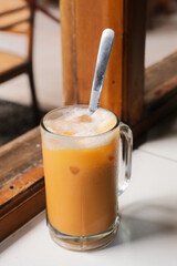 A glass of cold ice tea with milk called 