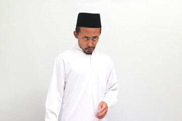 Ew, It's so gross. an Annoyed Indonesian man, wearing a songkok, peci, or kopiah, is repulsed by...