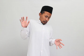 Ew, It's so gross. an Annoyed Indonesian man, wearing a songkok, peci, or kopiah, is repulsed by...