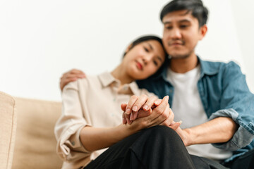 Happy asian Couple hugging on the day of the start of family life pregnant woman sitting on a couch in the living room at home. Counseling for fertility and pregnancy Becoming Parents