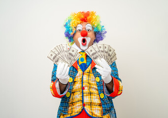 Mr Clown. Portrait of Funny face Clown man in colorful uniform standing holding a lot of money for gambling. Happy expression male bozo in various pose on isolated background.