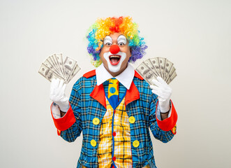 Mr Clown. Portrait of Funny face Clown man in colorful uniform standing holding a lot of money for...