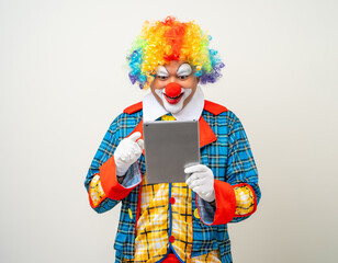 Mr Clown. Portrait of Funny face Clown man in colorful uniform standing holding tablet. Happy...
