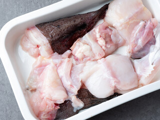 Raw monkfish cut into pieces on a plate