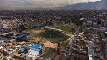Aerial view of a park with a small stadium in Bogotá with mountains and buildings in the background