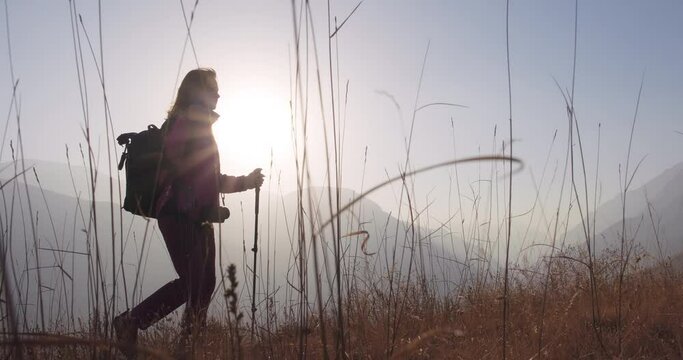 Active woman climbing the mountain. Healthy, active lifestyle and travel concept. Silhouette view